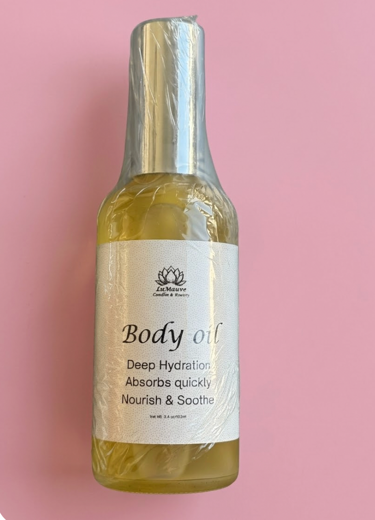 Body oil bottle with a label on a pink background
