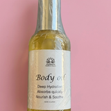 Body oil bottle with a label on a pink background