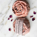 Himalayan salt bar with rose gold packaging on a marble surface with dried flowers.